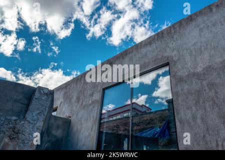 Enorme finestra di un edificio industriale o deposito sopra il cielo blu con nuvole lufy. Foto di alta qualità Foto Stock