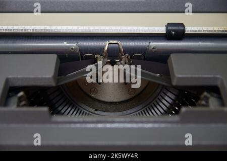 Raffiguri la parte centrale di una vecchia macchina da scrivere in cui spiccano la pressa per carta, il rullo, il nastro di una macchina da scrivere manuale Foto Stock