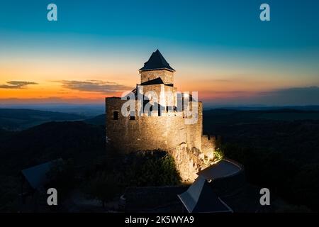Rinnovato monumento storico in Ungheria montagne. Foto panoramica aerea sulle rovine di un castello medievale vicino alla città di Holloko. Foto panoramica del paesaggio Foto Stock