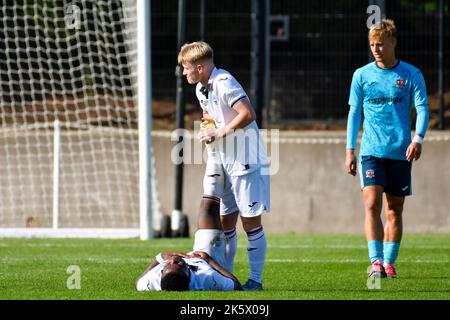 Swansea, Galles. 8 ottobre 2022. Daniel Watts di Swansea City aiuta il compagno di squadra Geoffroy Bony di Swansea City con un infortunio durante la partita della Coppa della Lega di sviluppo professionale tra Swansea City Under 18 e Exeter City Under 18 alla Swansea City Academy di Swansea, Galles, Regno Unito, il 8 ottobre 2022. Credit: Duncan Thomas/Majestic Media. Foto Stock