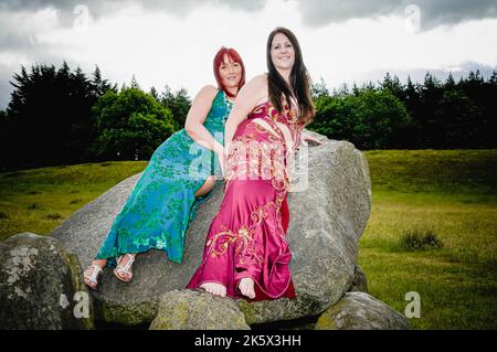 Due ballerini del ventre indossano un costume da bagno, posano al giant's Ring Stone dolmen, Belfast, Irlanda del Nord Foto Stock