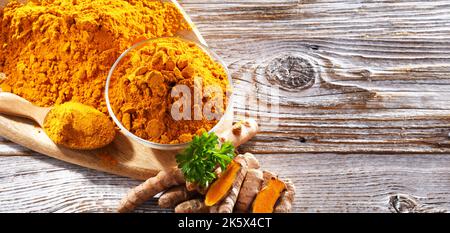 Composizione con una ciotola di curcuma macinato e il suo rizoma fresco. Foto Stock