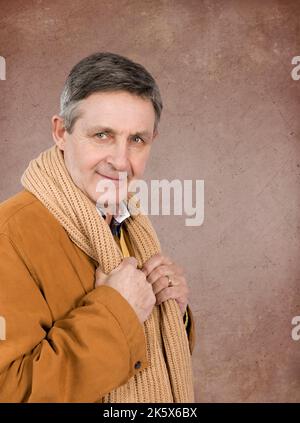 Attraente uomo anziano elegantemente vestito con giacca e sciarpa maglione Foto Stock