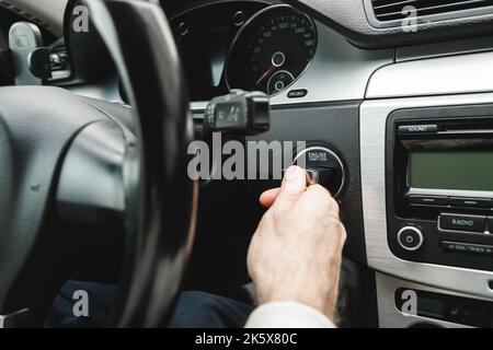 Mano dell'uomo inserire la chiave nel blocco di accensione della vettura.chiave di accensione della vettura.chiave della vettura inserita nel commutatore di accensione Foto Stock