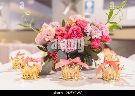 Elegante bouquet di fiori in vaso con bomboniere Crown Party color oro. Foto Stock