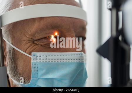 Un uomo anziano durante un esame ottico professionale Foto Stock