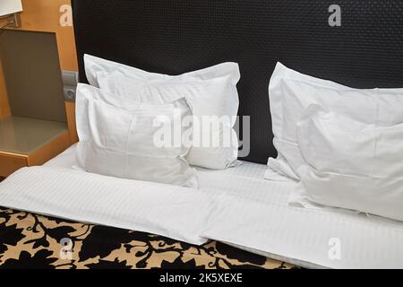 Letto d'hotel con lenzuola bianche Foto Stock