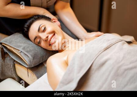 Donna che riceve massaggio rilassante collo Foto Stock