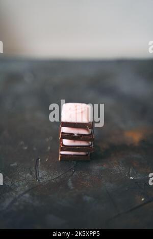 Fuoco selettivo su quattro fette di cioccolato su uno sfondo scuro. Foto Stock