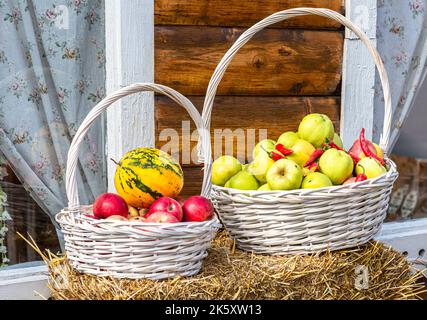 Cestini in legno di vimini con mele fresche mature in giardino in estate Foto Stock
