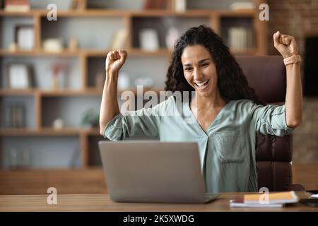 Emotivo giovane imprenditrice donna che celebra un affare di successo Foto Stock