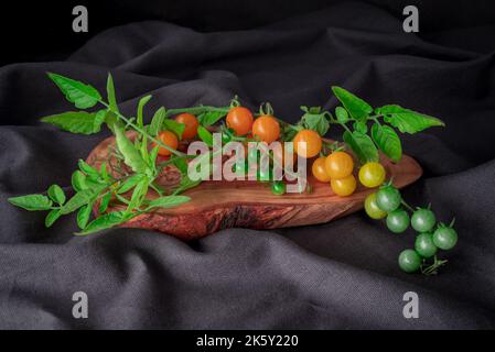 pomodori rossi ramificazione su sfondo tavolo, cibo sano Foto Stock