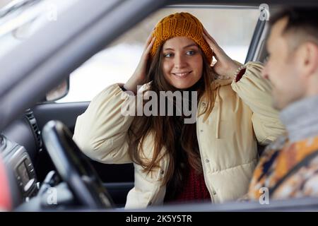 Ritratto di giovane donna sorridente in macchina con ragazzo, pronto per una fuga invernale insieme Foto Stock