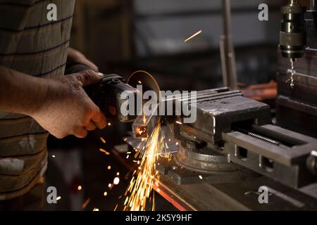 Trattamento del metallo. Rettifica dell'acciaio. Scintille dal disco. Foto Stock