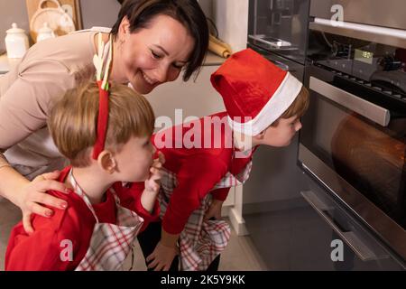 Famiglia in attesa di biscotti di pan di zenzero per cucinare nel forno Foto Stock