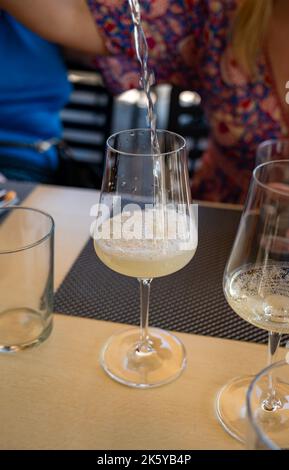 Bere txakoli o Chacolí vino bianco leggermente frizzante molto secco prodotto nei Paesi Baschi spagnoli, servito nel ristorante di Getaria pescatore Foto Stock