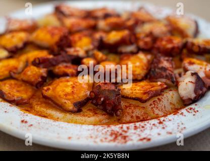 Gustosi frutti di mare, polpo alla griglia in stile galiziano con paprika pimento rosso e patate serviti nel ristorante spagnolo Foto Stock