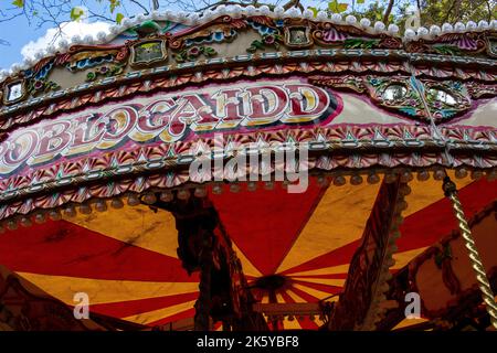 Fiera di Parsons Green, West London, Regno Unito; giostre colorate super luminose, mongolfiere, Auto, treni e Spiderman Foto Stock