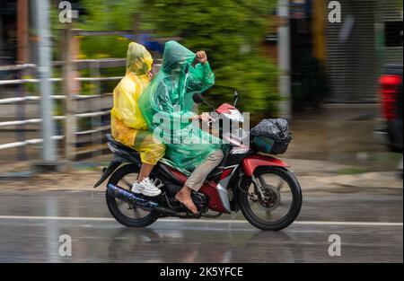 SAMUT PRAKAN, THAILANDIA, 21 2022 SETTEMBRE, coppia in impermeabile guidare sotto la pioggia Foto Stock