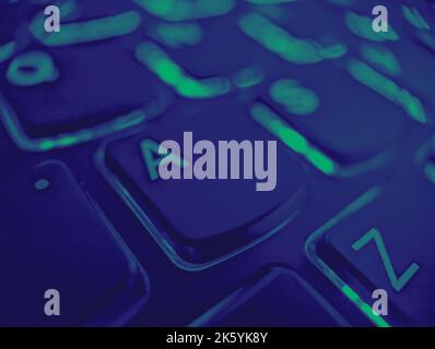 Vista in primo piano dei tasti A e Z sulla tastiera di un computer portatile con luci accese e effetto di colore verde e blu Foto Stock