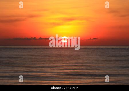 Un'immagine di un bel tramonto rosso con un grande sole giallo Foto Stock