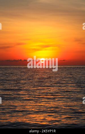 Un'immagine di un bel tramonto rosso con un grande sole giallo Foto Stock