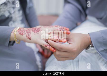 Lo sposo ha messo un anello di nozze sulla mano della sposa Foto Stock