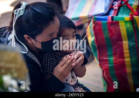 Nong Bua Lamphu, Thailandia. 11th Ott 2022. I lori illuminano incenso di fronte a un memoriale fuori da Wat Rat Samakee nella provincia di Nong Bua Lamphu, Thailandia durante i riti funebri per le vittime della tragedia. Un assalitore ha usato una combinazione di armi e coltelli per uccidere 35 persone, con almeno 22 bambini vittime al centro di cura, prima di uccidere sua moglie e figlio e poi commettere suicidio, portando il totale del corpo a 38. (Credit Image: © Adryel Talamantes/ZUMA Press Wire) Foto Stock