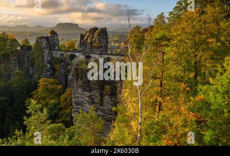 Rathen, Germania. 11th Ott 2022. La luce del sole cade al mattino sugli alberi di colore autunnale nel Parco Nazionale della Svizzera Sassone vicino al Ponte di Bastei costruito nel 1851. Il Lilienstein può essere visto sullo sfondo. Credit: Robert Michael/dpa/Alamy Live News Foto Stock