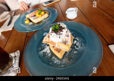 Toast alla cannella alla francese con fette di mango servite con cialda semplice al burro Foto Stock