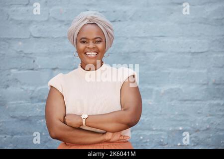 Una donna d'affari afroamericana sorridente con il velo che posa con le braccia incrociate su uno sfondo grigio. Ritratto di fiducioso, di successo Foto Stock