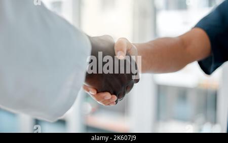 Due medici scuotono le mani mentre lavorano insieme in un ospedale. I professionisti medici si salutano mentre lavorano in una clinica. Colleghi Foto Stock