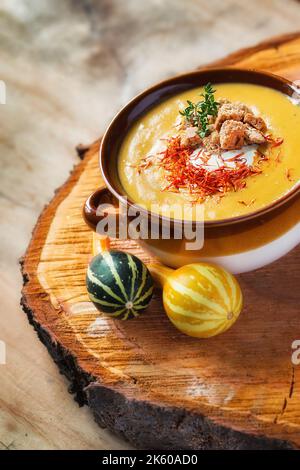 Una zuppa di zucca di stagione decorata con erbe (fuoco selettivo) Foto Stock