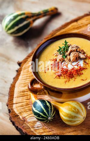 Una zuppa di zucca di stagione decorata con erbe (fuoco selettivo) Foto Stock