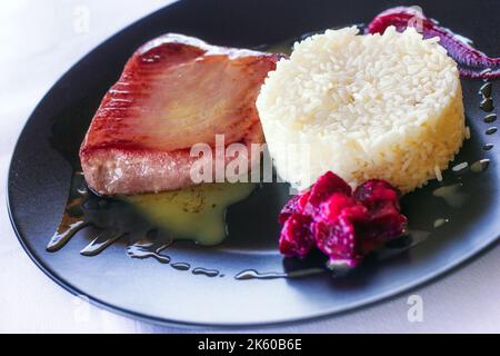 Bistecca di tonno fresco di Naxia saltata in olio d'oliva, con purea di riso e barbabietola (fuoco selettivo) Foto Stock