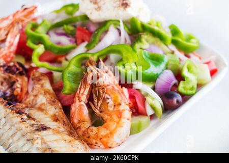 Pesce alla griglia con insalata e formaggio feta (focalizzazione selettiva) Foto Stock