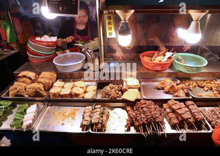 KEELUNG, TAIWAN - 22 NOVEMBRE 2018: I venditori preparano il cibo al mercato notturno di Miaokou a Keelung, Taiwan. I mercati notturni sono parte essenziale di Taiwanese fo Foto Stock