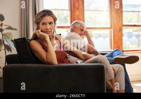 Coppia, anziani e arrabbiato sul divano per argomento, lotta o disputa in casa insieme. Stress, triste e frustrato con silenzio sul divano in soggiorno a. Foto Stock