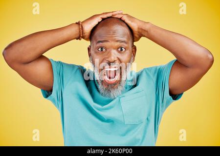 Uomo africano-americano maturo con barba grigia in piedi con le mani sulla testa e guardando scioccato o sorpreso. Uomo con viso stupito Foto Stock