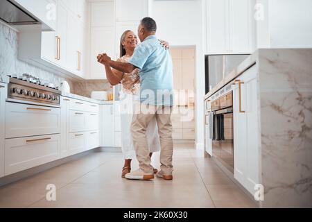 Coppia, anziani e danza in cucina per amore, romanticismo e felice insieme mentre a casa in pensione. Senior, uomo e donna fanno divertente ballare in casa per Foto Stock