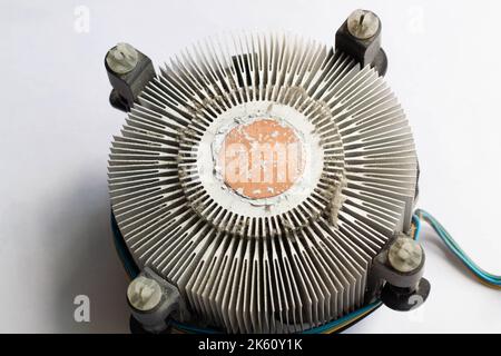Radiatore di raffreddamento molto sporco per un processore di computer. Refrigeratore in alluminio polveroso per un microchip CPU su una scheda madre di un computer con tracce di raffreddamento Foto Stock