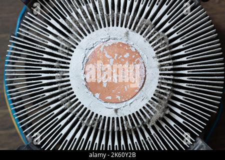 Radiatore di raffreddamento molto sporco per un processore di computer. Refrigeratore in alluminio polveroso per un microchip CPU su una scheda madre di un computer con tracce di raffreddamento Foto Stock