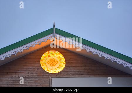 Notte Vista ravvicinata del tetto di una casa con illuminato Vegan Sun yoga Foto Stock
