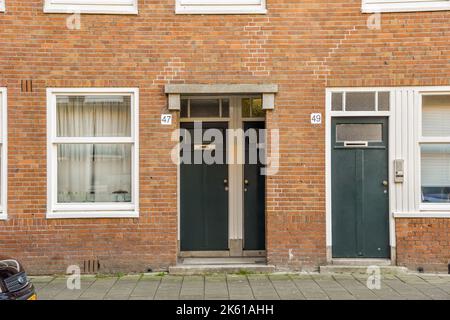 Entrata esterna dell'edificio con pareti in mattoni e finestre lungo il sentiero del marciapiede Foto Stock