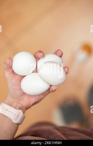 uovo rotto e piedi sul pavimento in cucina, vista dall'alto Foto Stock