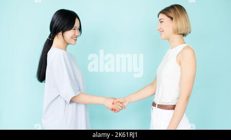 cordiale stretta di mano felice donne prima riunione Foto Stock