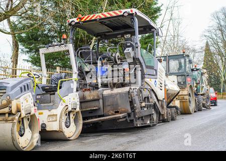 Attrezzature per la lavorazione su strada del Regno Unito, inclusi grandi rulli, parcheggiate all'aperto vicino al cantiere stradale. Foto Stock