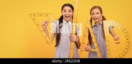 Scuole ragazze amici. È arrivato il ritorno a scuola. Le ragazze felici tengono gli attrezzi geometrici. Torna a scuola. Lezione di geometria. Banner della studentessa scolastica Foto Stock