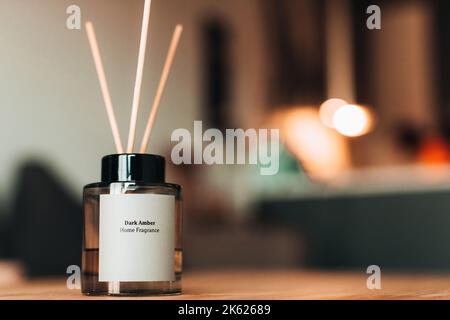 Elegante bottiglia in vetro con diffusori di aroma in legno su tavolo in legno. Decorazione domestica. Concetto minimalista di deodorante per ambienti. Fragranza domestica Foto Stock