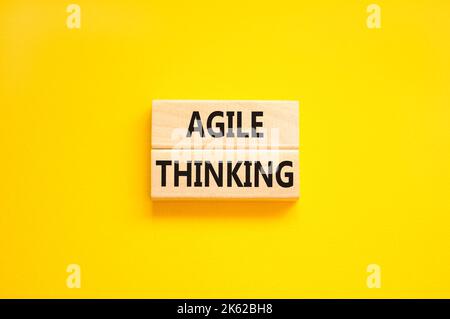 Simbolo del pensiero agile. Concetto parole Agile pensare su blocchi di legno. Bella tavola giallo sfondo giallo. Business flessibile e agile c Foto Stock